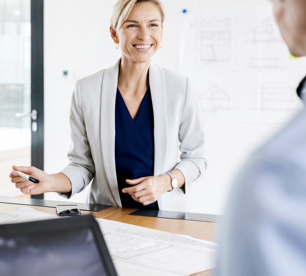 Smiling businessman sitting in hammock, using laptop